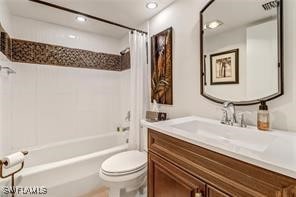 bathroom with vanity, shower / bath combination with curtain, and toilet