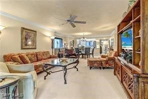 carpeted living room with crown molding and ceiling fan with notable chandelier