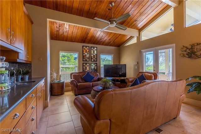 living room with wooden ceiling, light tile patterned floors, sink, ceiling fan, and vaulted ceiling with beams