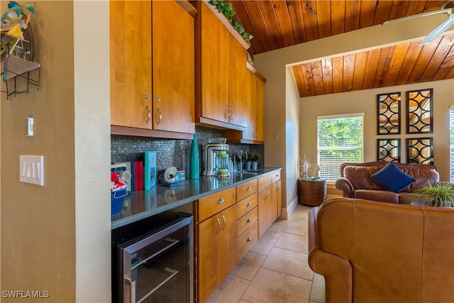 kitchen featuring wooden ceiling, beverage cooler, tasteful backsplash, sink, and light tile patterned flooring