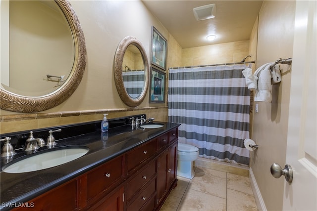 bathroom with tile patterned floors, toilet, curtained shower, and vanity