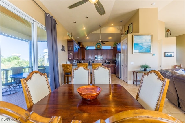 dining area with ceiling fan, light tile patterned floors, and high vaulted ceiling