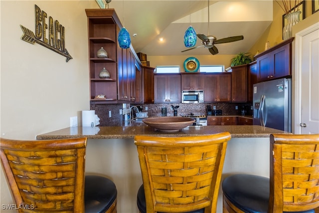 kitchen featuring lofted ceiling, kitchen peninsula, appliances with stainless steel finishes, and ceiling fan