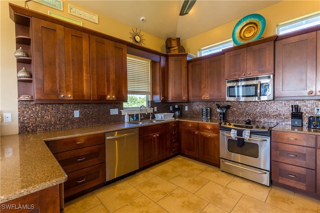 kitchen featuring backsplash, stainless steel appliances, stone counters, and sink