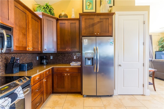 kitchen with backsplash, stainless steel appliances, stone counters, and light tile patterned flooring