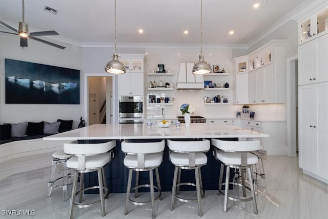 kitchen featuring a spacious island, white cabinets, decorative light fixtures, and backsplash