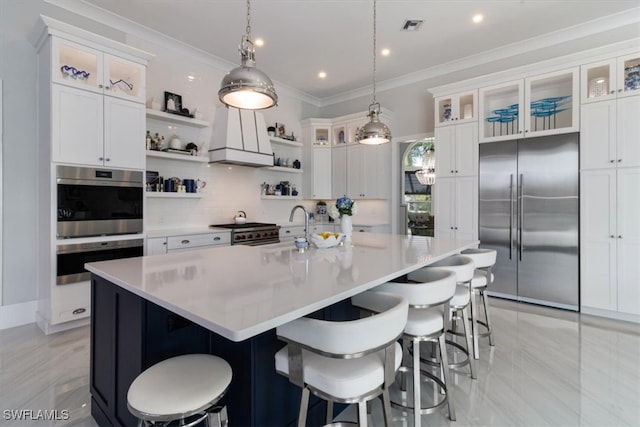 kitchen featuring a large island, white cabinetry, stainless steel appliances, and decorative light fixtures