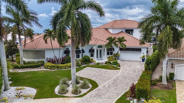 mediterranean / spanish house featuring a front lawn and a garage