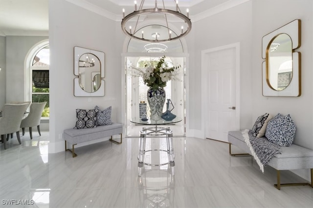 foyer entrance with crown molding and a notable chandelier