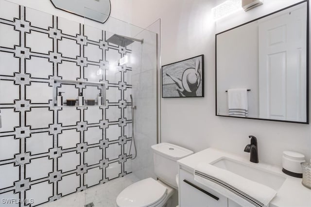 bathroom featuring vanity, tiled shower, and toilet