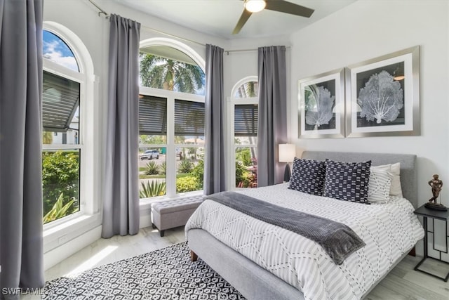 bedroom with light hardwood / wood-style flooring, multiple windows, and ceiling fan