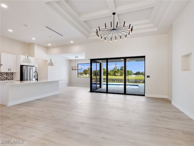 unfurnished living room with a chandelier and light hardwood / wood-style flooring