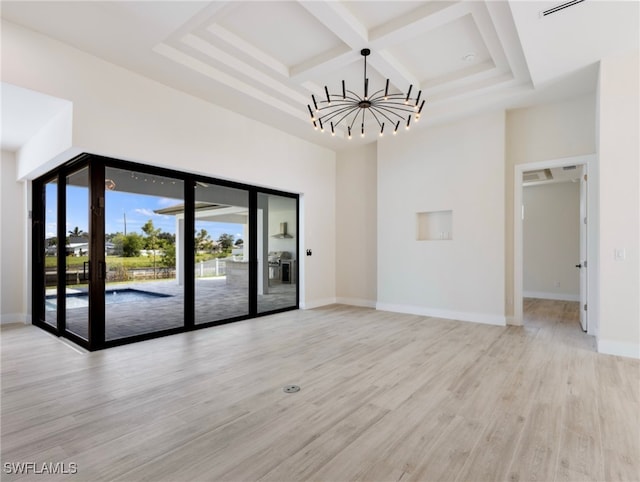 unfurnished room with coffered ceiling, an inviting chandelier, light hardwood / wood-style floors, and beam ceiling