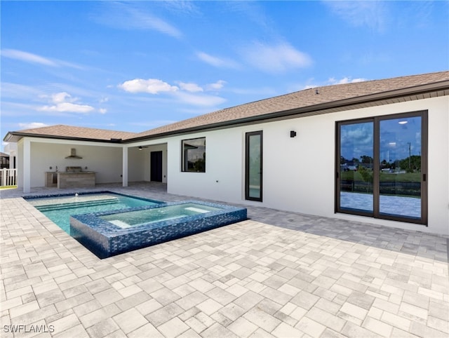 back of house with a swimming pool with hot tub and a patio area