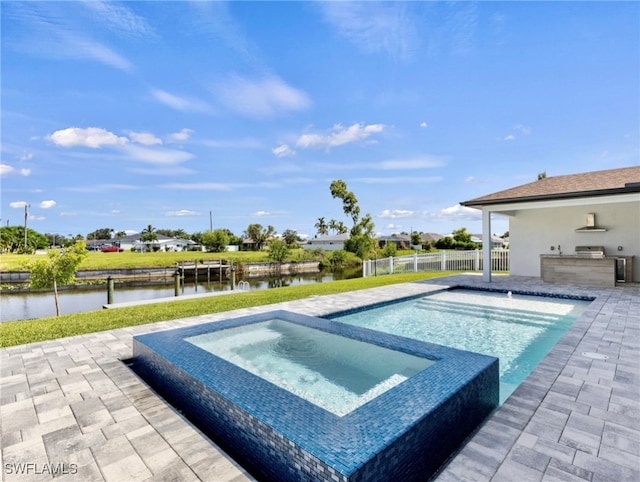 view of swimming pool featuring an in ground hot tub, a water view, and a patio area