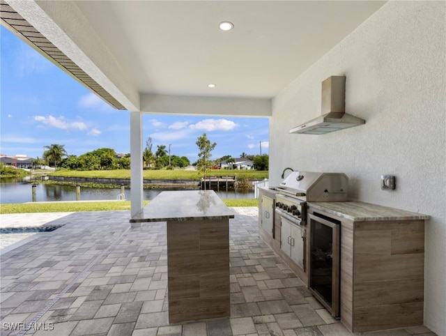 view of patio / terrace with grilling area, wine cooler, a water view, and exterior kitchen