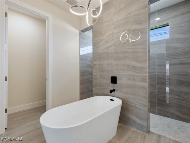 bathroom with a tub to relax in and hardwood / wood-style floors