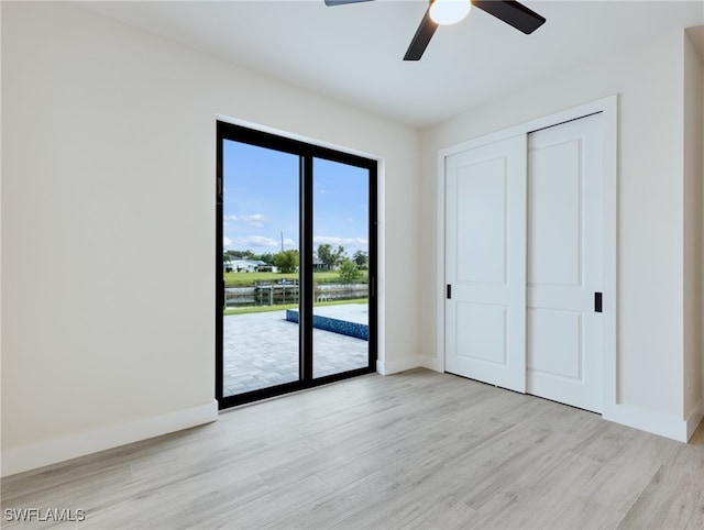 unfurnished bedroom with access to outside, light hardwood / wood-style floors, ceiling fan, and a closet