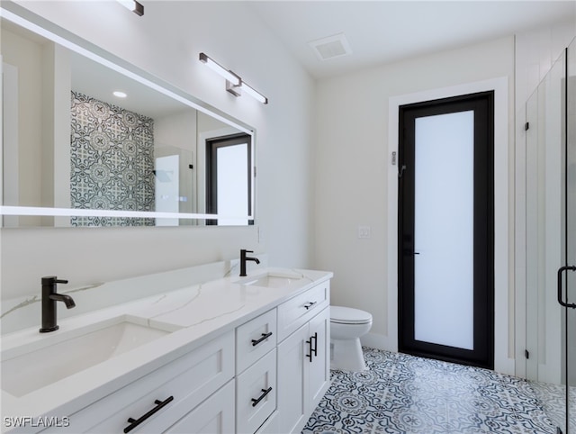 bathroom featuring toilet, an enclosed shower, and vanity