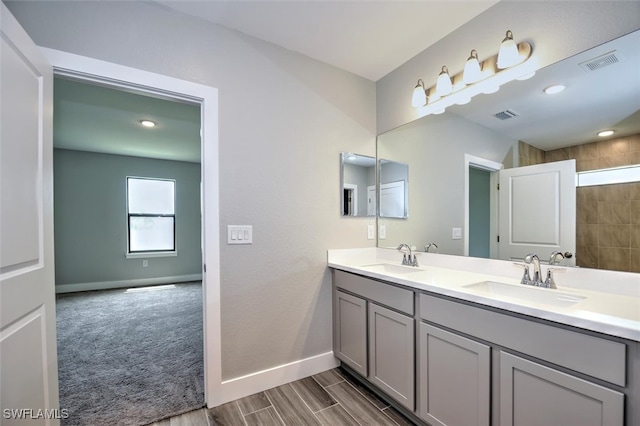 bathroom featuring a tile shower and vanity