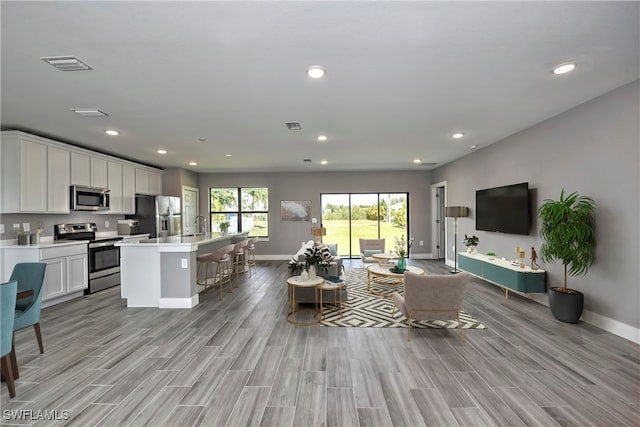 living room featuring sink and light hardwood / wood-style floors