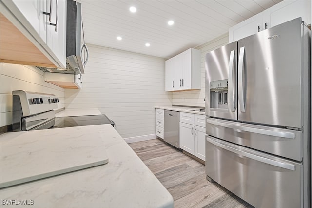 kitchen with light hardwood / wood-style flooring, light stone countertops, tasteful backsplash, white cabinetry, and stainless steel appliances