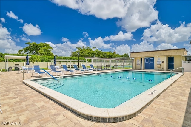 view of pool with a patio and an outdoor structure