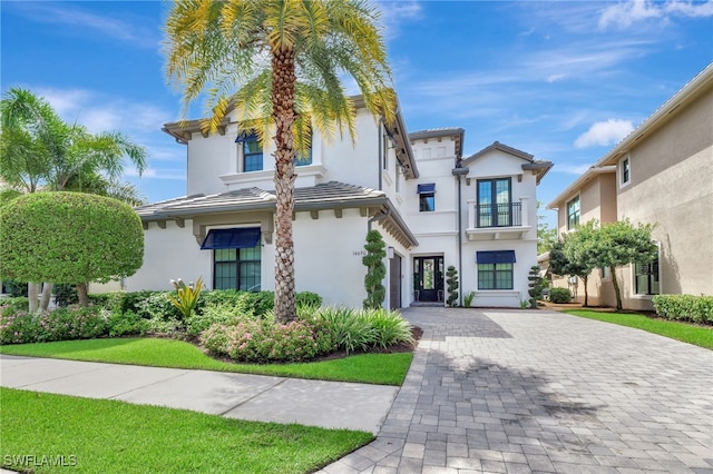 14690 Reserve Pl, Naples, FL 34109 - view of front of property with a balcony, stucco siding, decorative driveway, and a garage