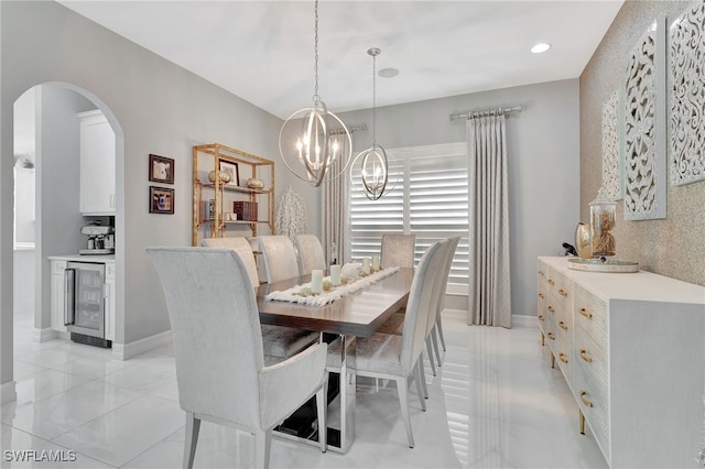 14690 Reserve Pl, Naples, FL 34109 - dining space with wine cooler, arched walkways, a chandelier, light tile patterned floors, and recessed lighting