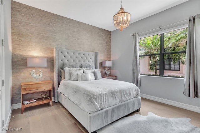 bedroom with hardwood / wood-style flooring and a chandelier