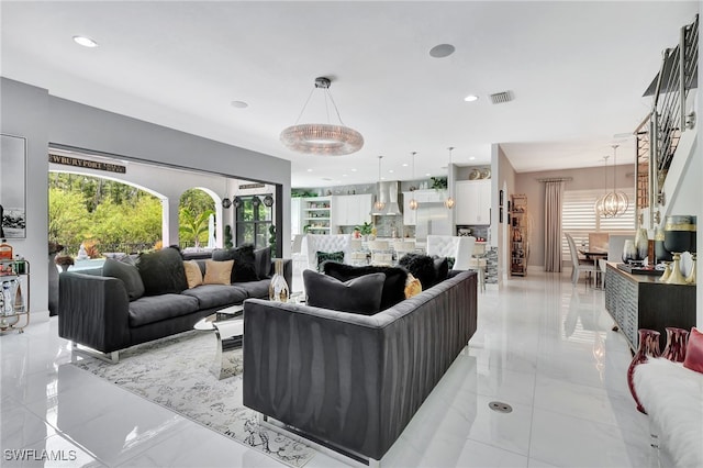 tiled living room with a notable chandelier and a healthy amount of sunlight