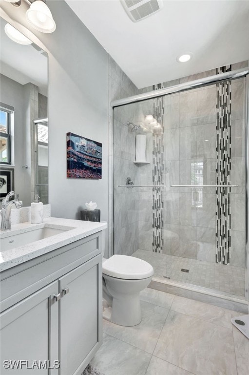 bathroom featuring an enclosed shower, toilet, and vanity