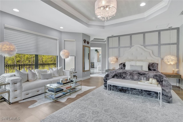 bedroom with light wood-type flooring, ornamental molding, an inviting chandelier, and ensuite bathroom