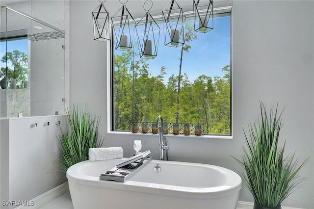 14690 Reserve Pl, Naples, FL 34109 - full bathroom featuring a sink, a freestanding tub, a tile shower, and baseboards
