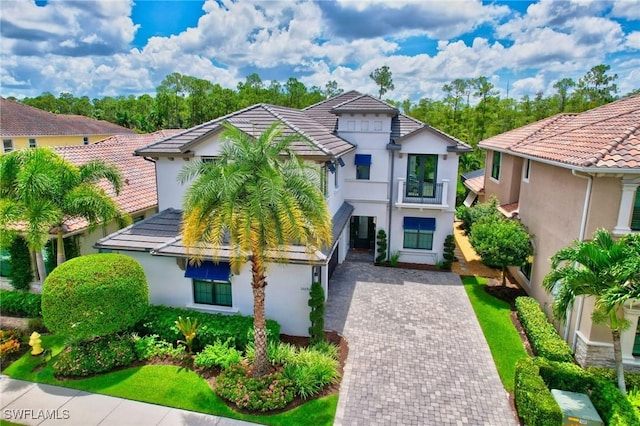 14690 Reserve Pl, Naples, FL 34109 - view of front of home featuring stucco siding, driveway, a tile roof, and a balcony