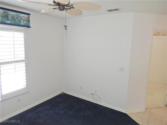 unfurnished room featuring light tile patterned flooring, ceiling fan, and plenty of natural light