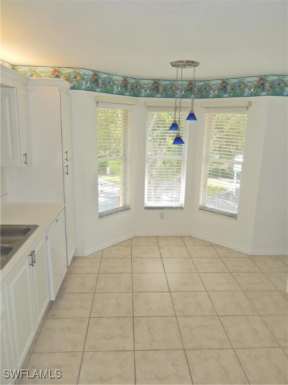 unfurnished dining area with light tile patterned flooring, plenty of natural light, and sink