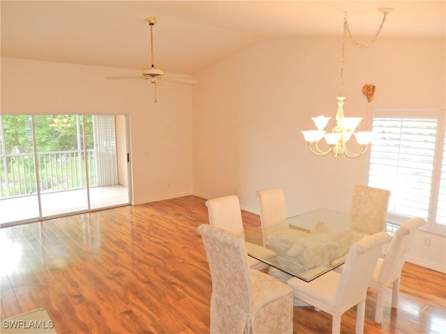 dining room with ceiling fan with notable chandelier, vaulted ceiling, and plenty of natural light