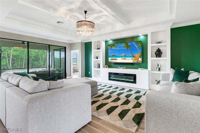 living room featuring a raised ceiling, wood-type flooring, and a chandelier