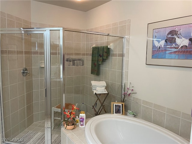 bathroom featuring separate shower and tub