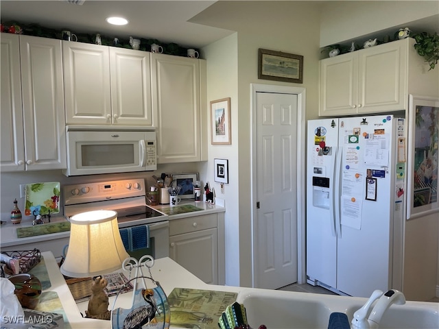 kitchen featuring white cabinets, white appliances, and sink