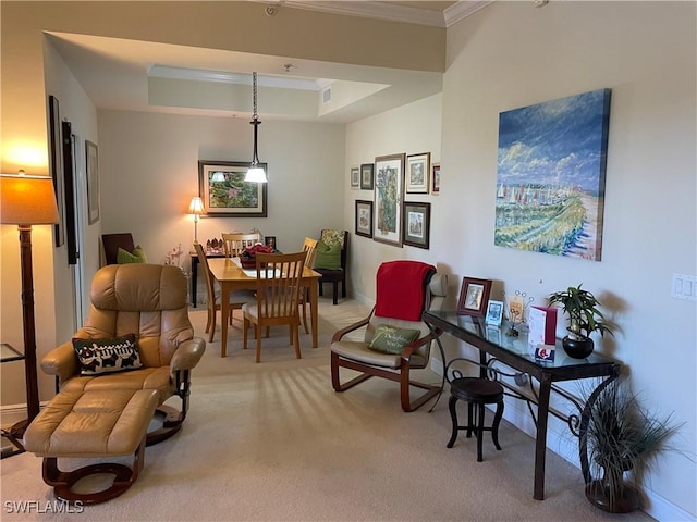 living area featuring light carpet, a tray ceiling, and ornamental molding