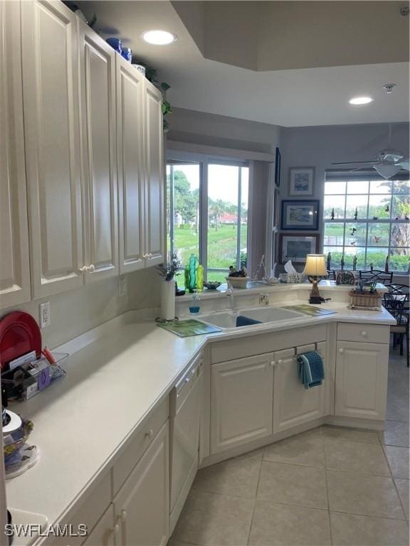 kitchen featuring light countertops, white cabinetry, dishwasher, and a sink