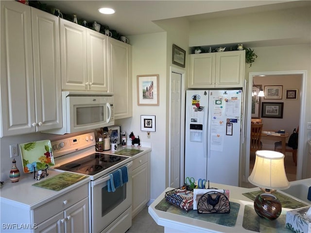 kitchen with light countertops, white appliances, and white cabinets