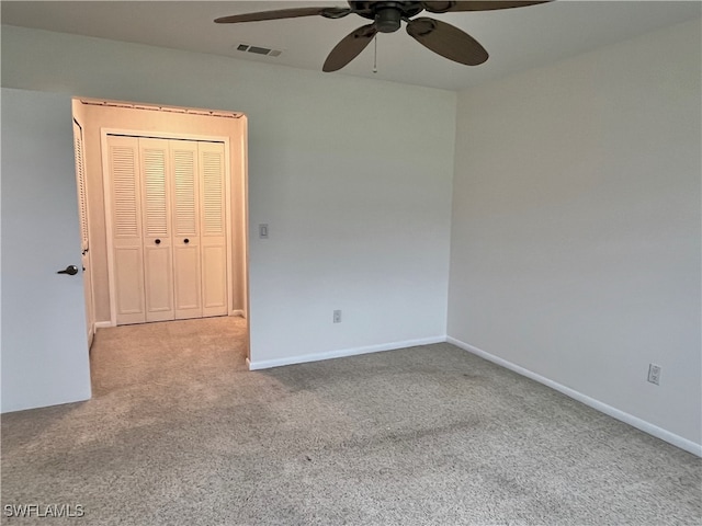 carpeted spare room with ceiling fan