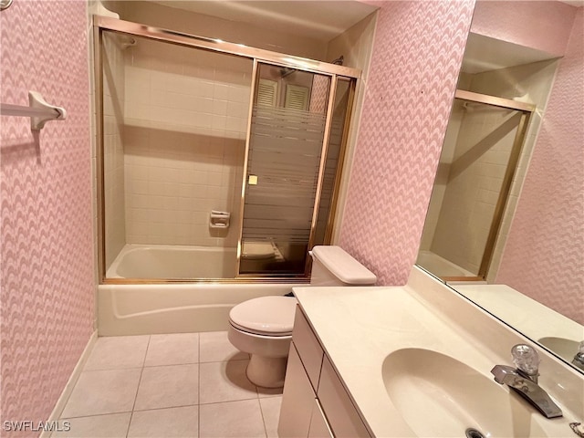 full bathroom featuring tile patterned flooring, vanity, toilet, and bath / shower combo with glass door