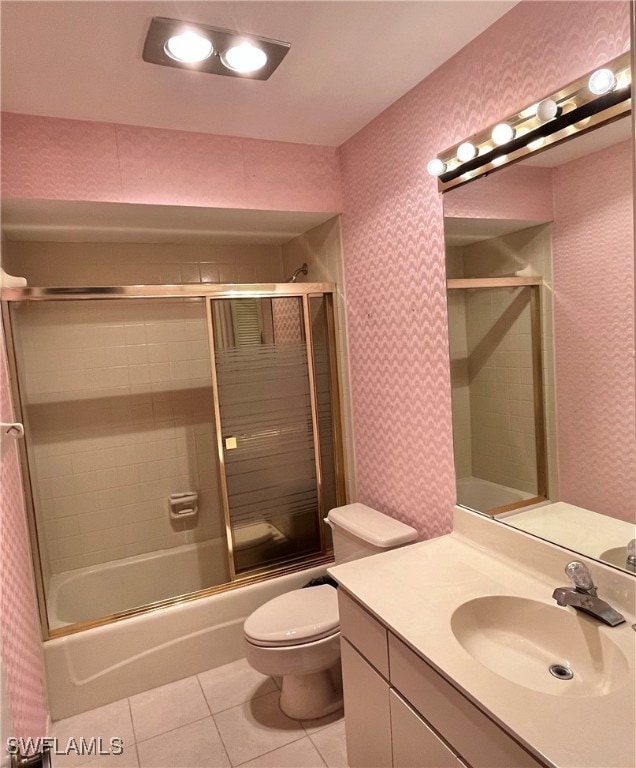 full bathroom featuring tile patterned floors, shower / bath combination with glass door, vanity, and toilet