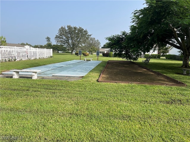 view of sport court with a yard