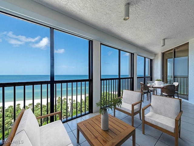 sunroom / solarium with a beach view and a water view