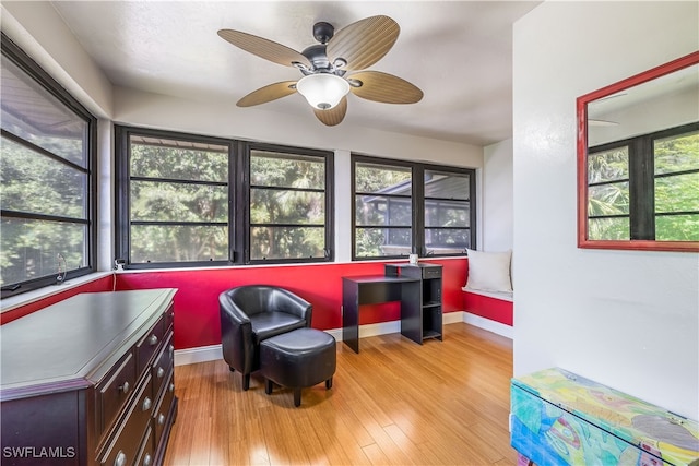 living area featuring light hardwood / wood-style flooring, ceiling fan, and a healthy amount of sunlight